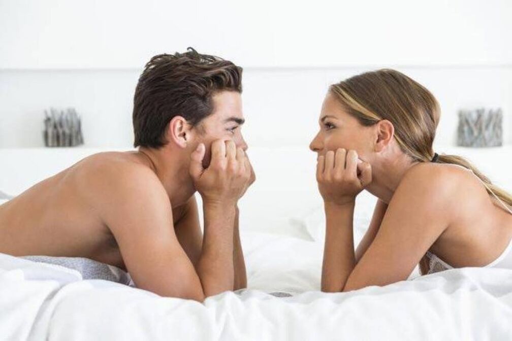μια γυναίκα στο κρεβάτι με έναν άντρα με διευρυμένο πέος